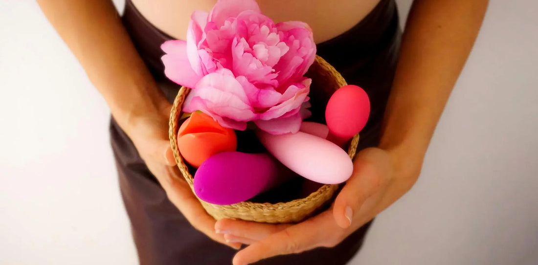 Hands holding a basket with colorful vibrators and pink flowers showing how to use a suction vibrator